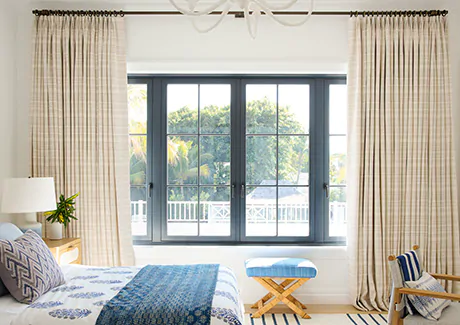 the-shade-store-tailored-pleat-drapery-victoria-hagan-tidal-line-sand-blinds-vs-curtains-blue-accents-bedroom-content-2023-palm-beach-460x325px